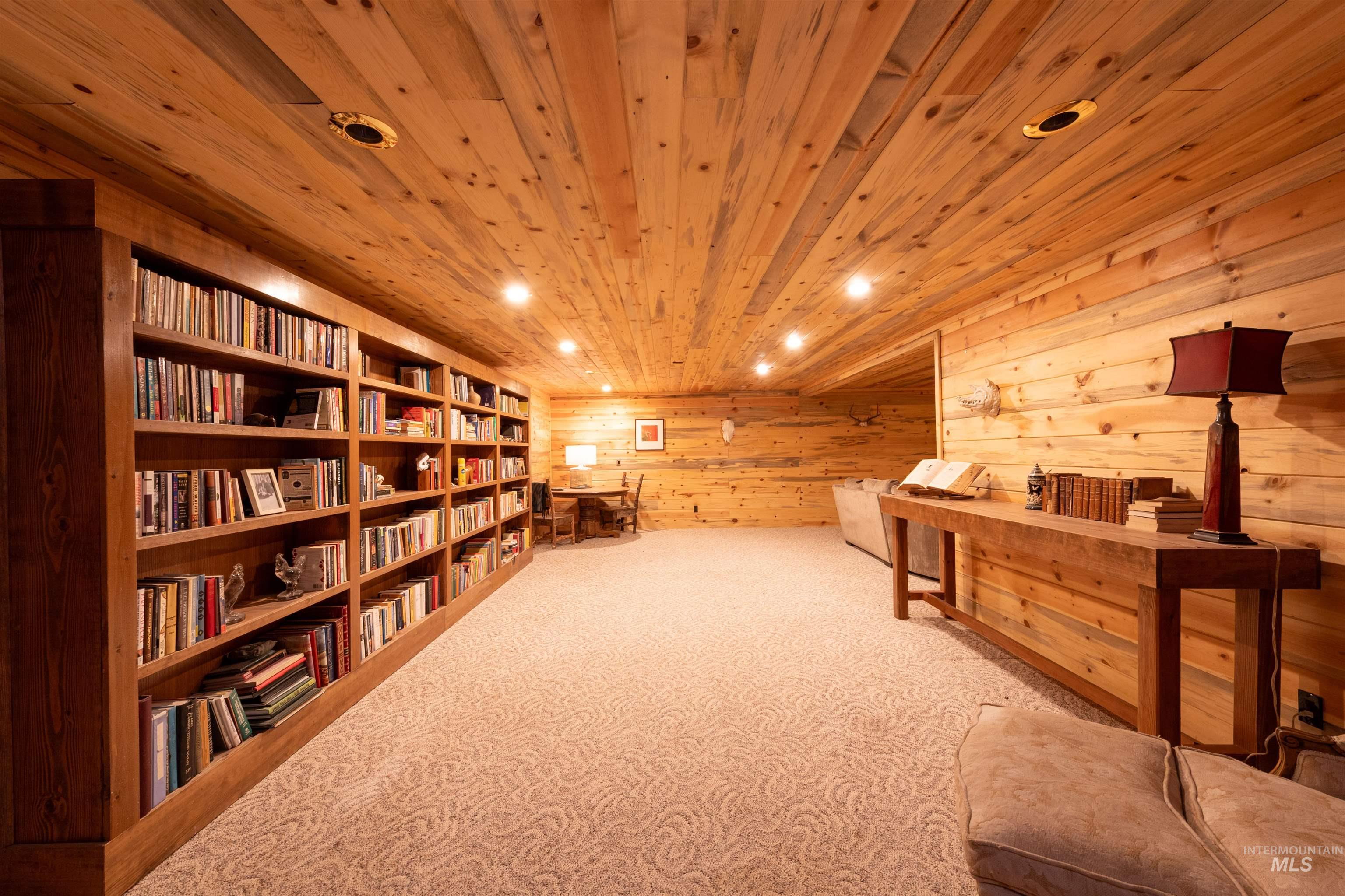 Sitting room with carpet, wooden walls, recessed lighting, and wood ceiling