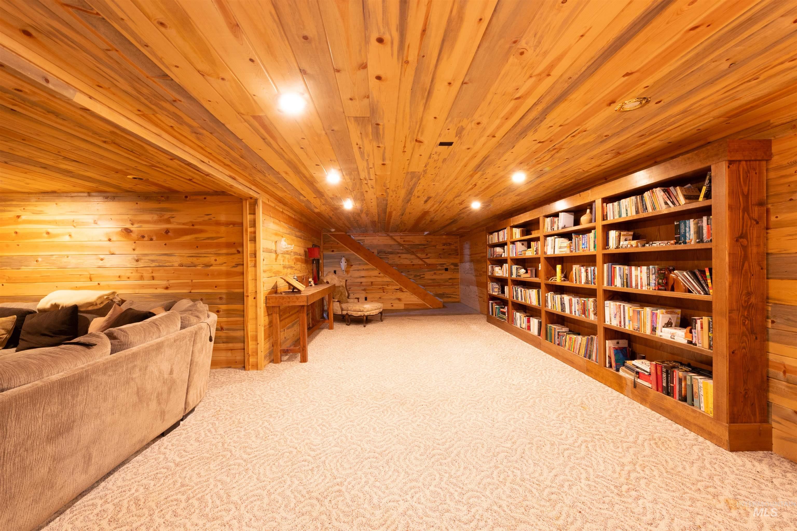Sitting room featuring wood walls, light colored carpet, recessed lighting, and wooden ceiling