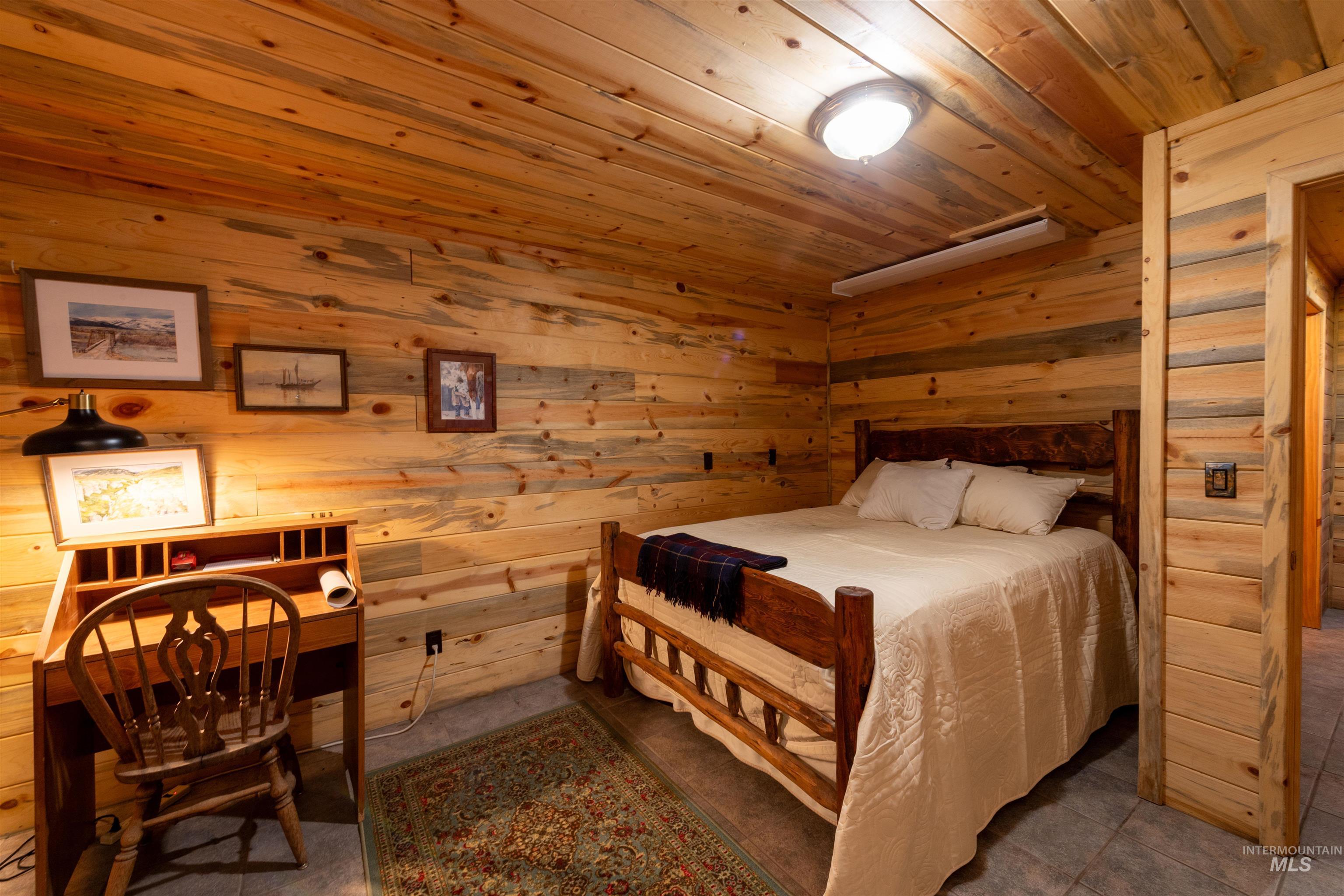 Tiled bedroom featuring wood ceiling and wooden walls