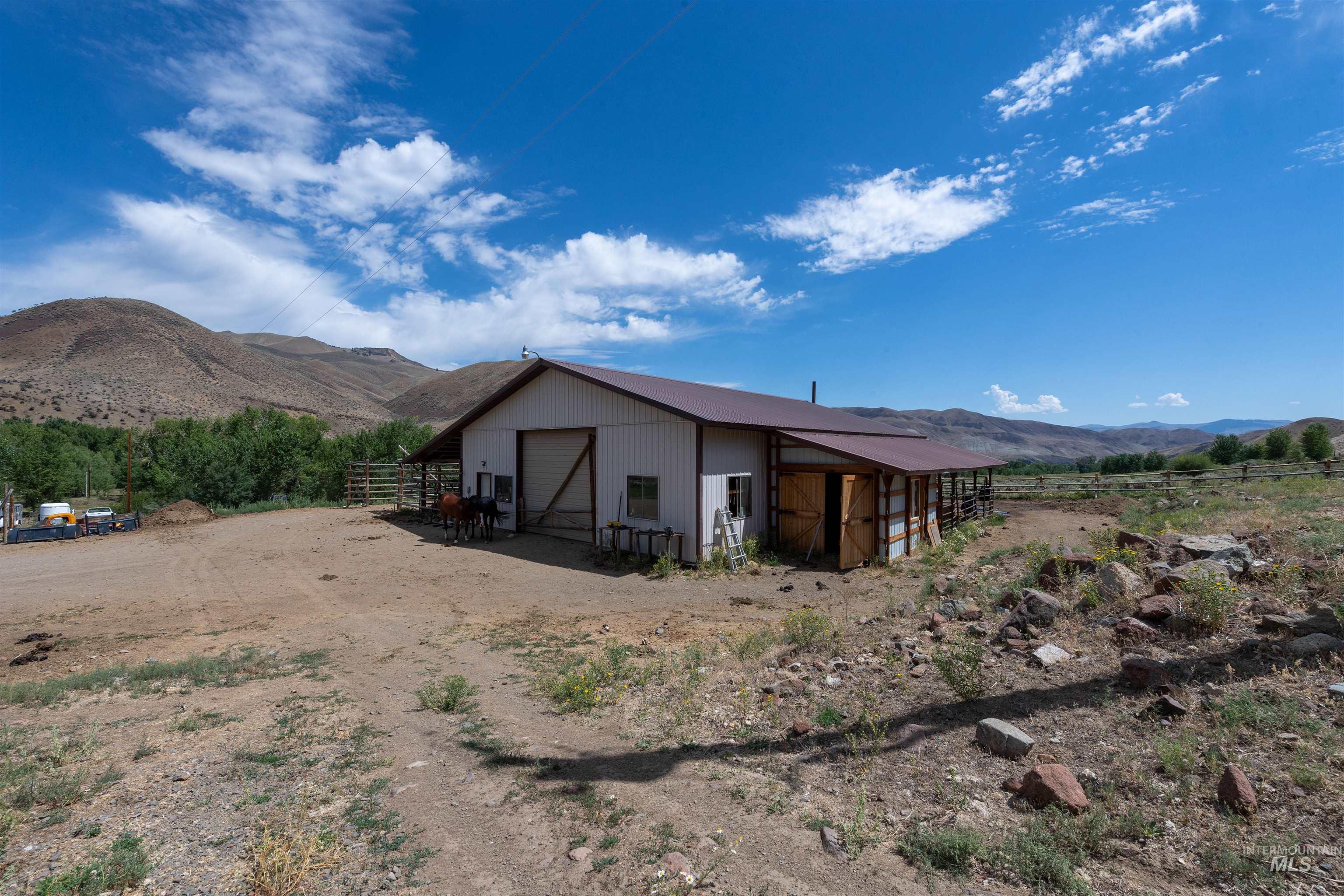 View of outbuilding with a mountain view, an exterior structure, a view of rural / pastoral area, and driveway