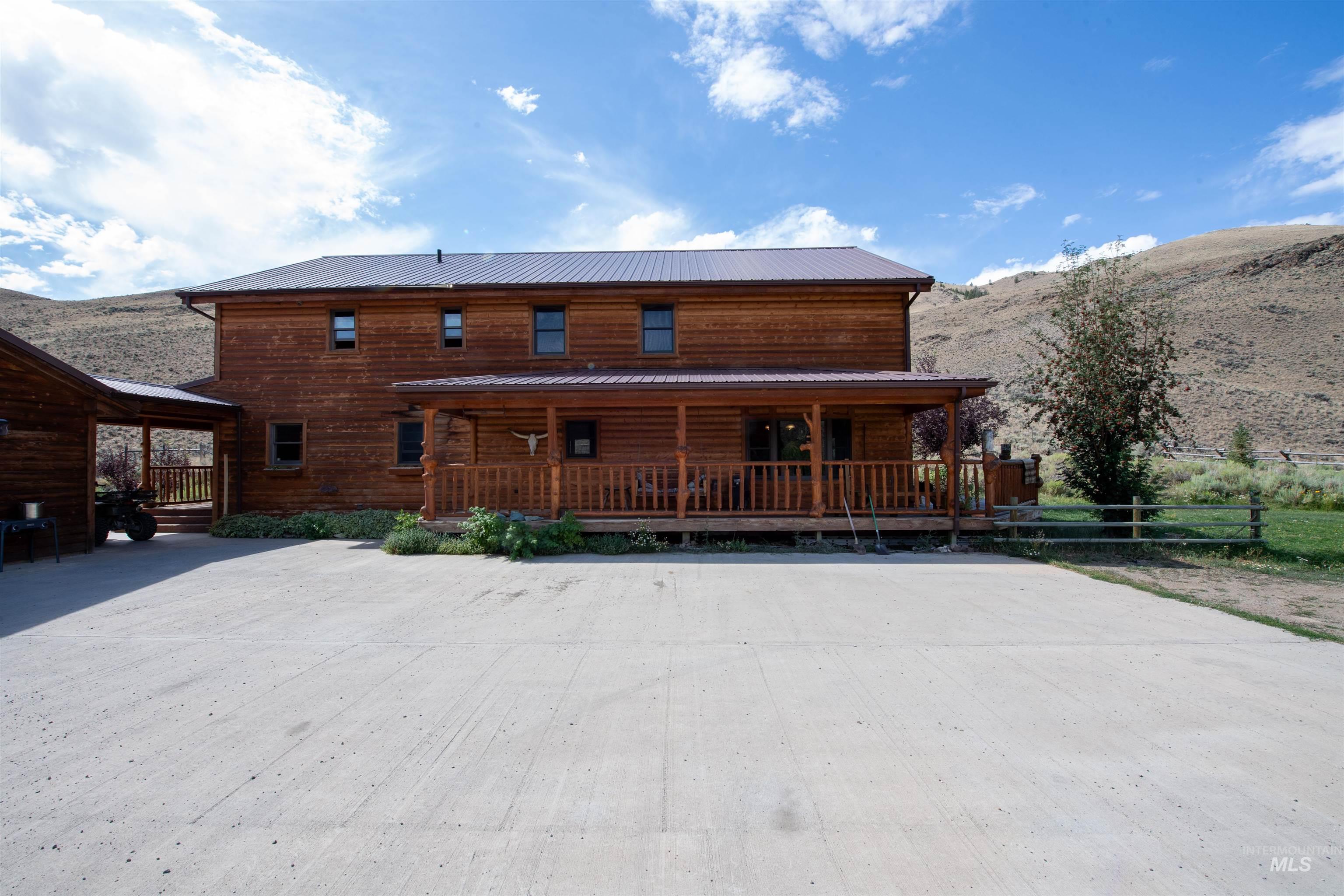 Back of house with a mountain view, covered porch, and a metal roof