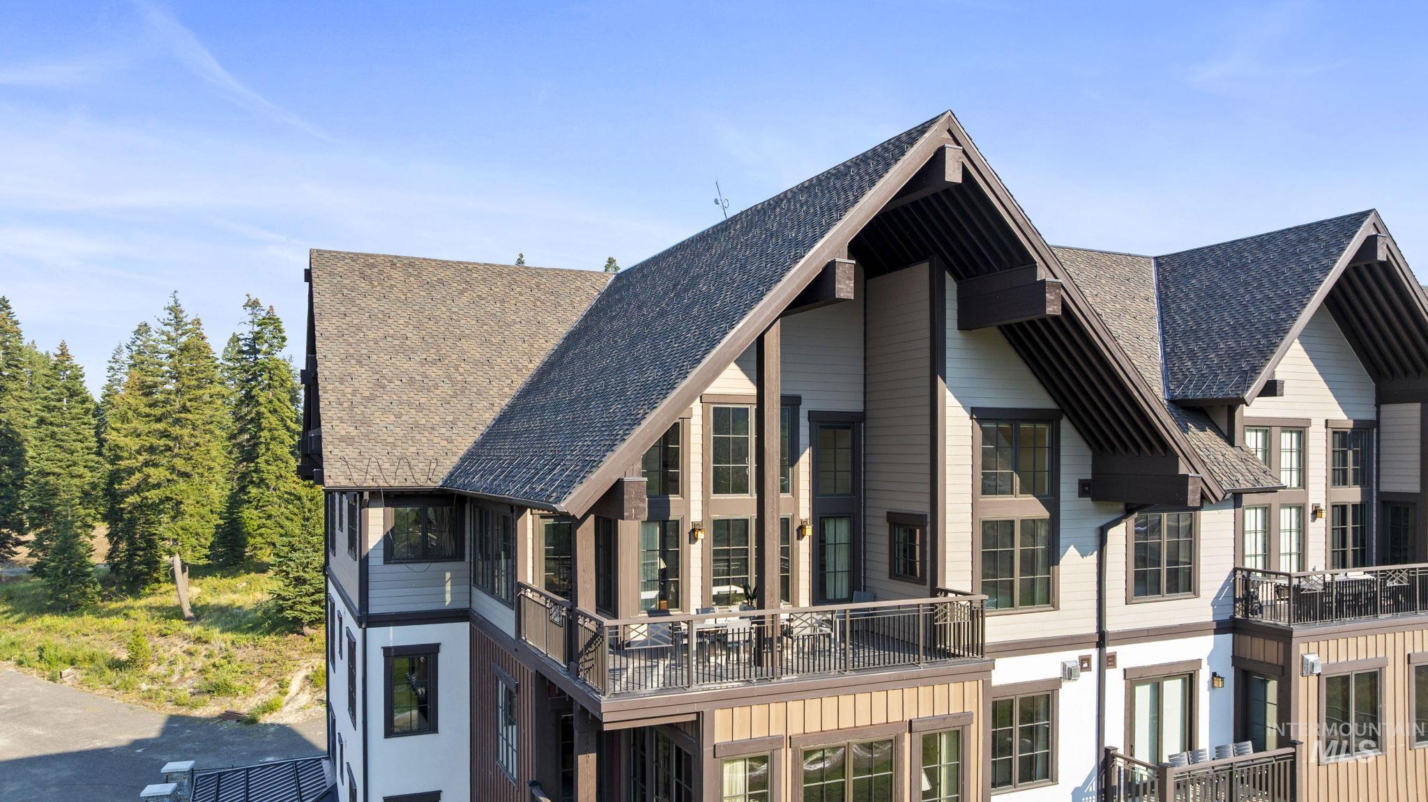 Rear view of house with a balcony and roof with shingles