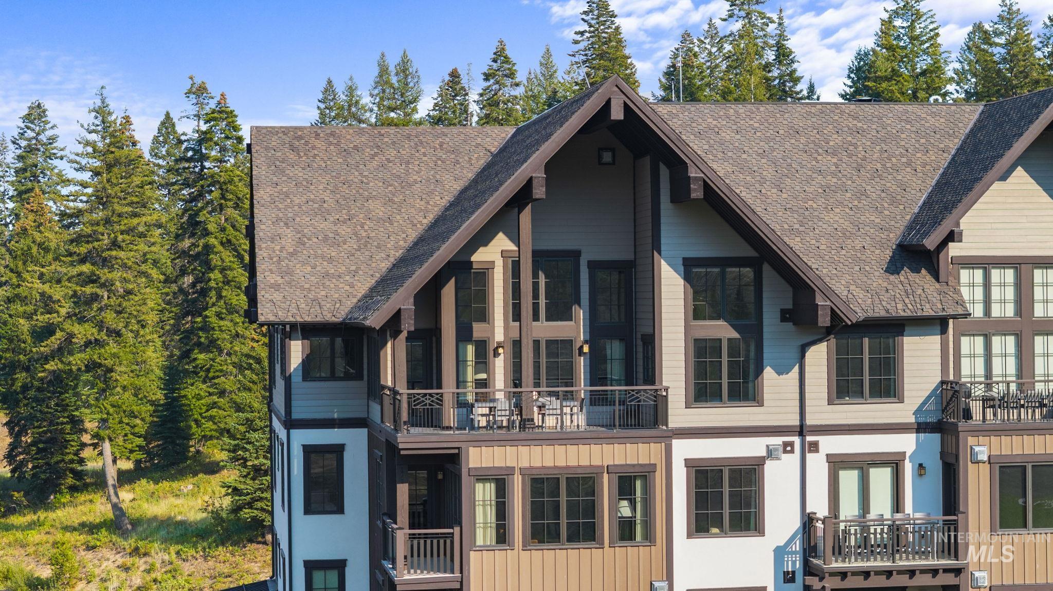 Rear view of property with a balcony, board and batten siding, and a shingled roof
