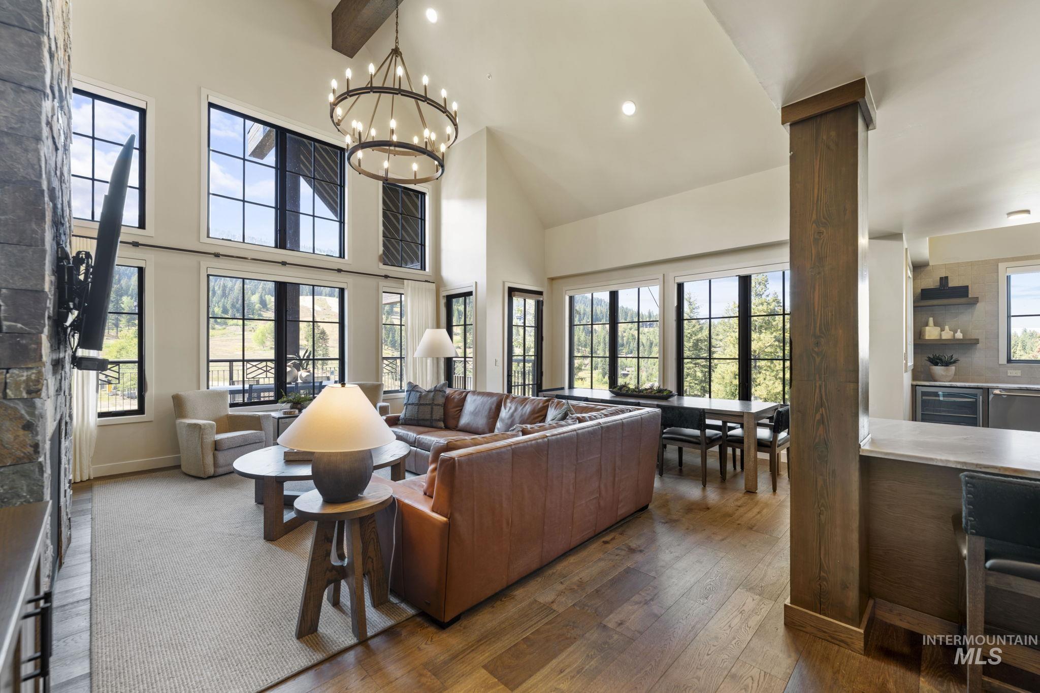 Living area with dark wood-style flooring, recessed lighting, high vaulted ceiling, beverage cooler, and beamed ceiling