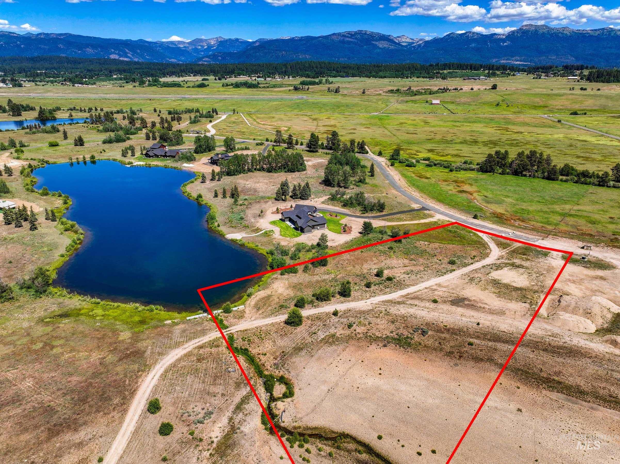 Aerial view of sparsely populated area with a water and mountain view and property boundaries highlighted