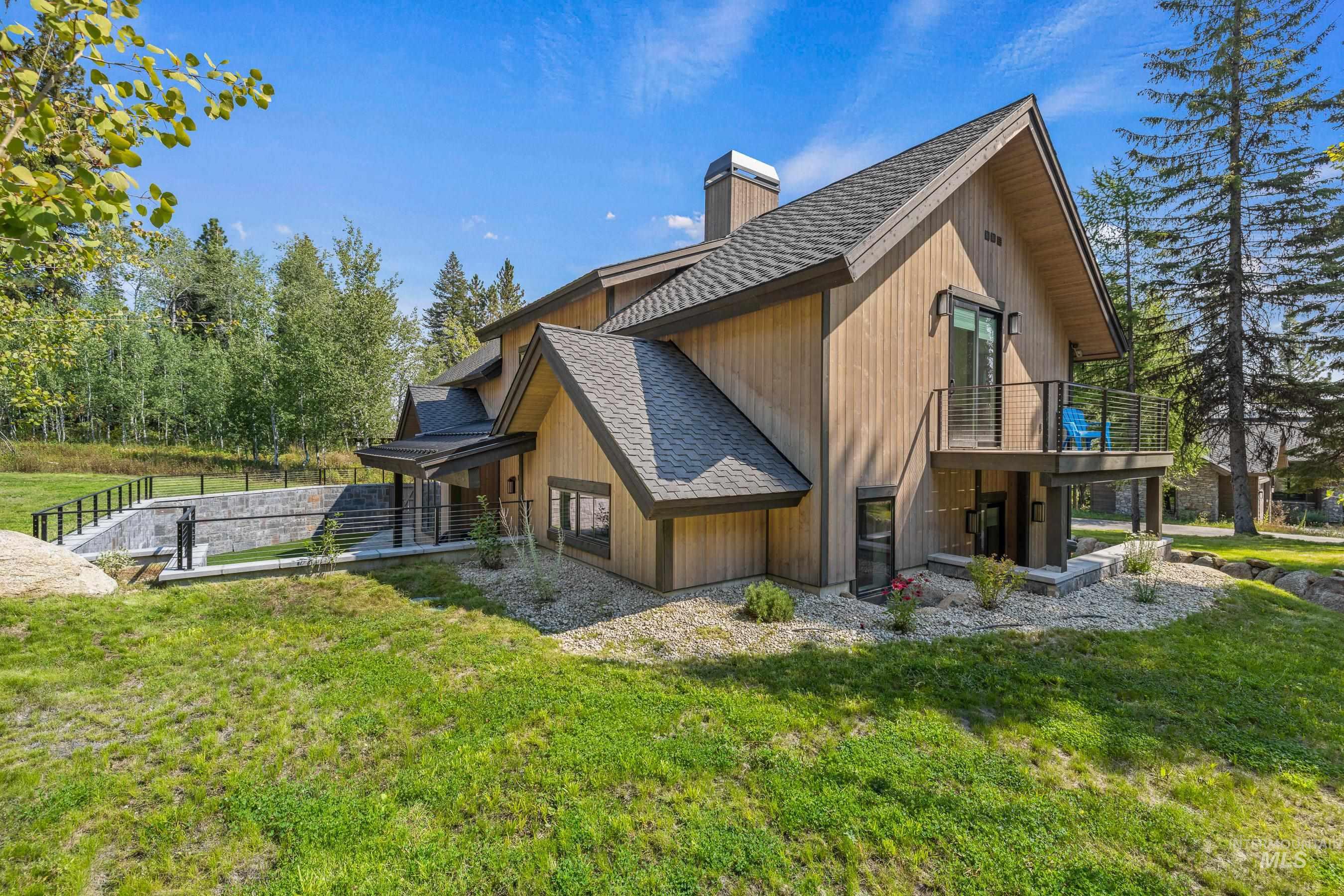 View of property exterior with a chimney, a shingled roof, and a lawn