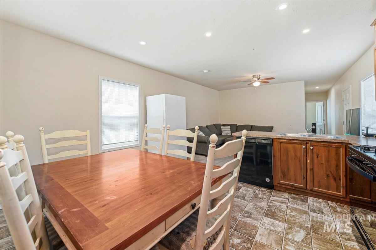 Dining space with recessed lighting, healthy amount of natural light, ceiling fan, and light stone finish flooring