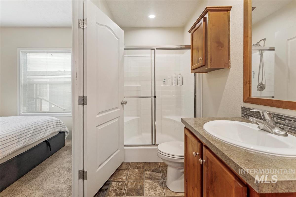 Ensuite bathroom featuring a shower stall and vanity