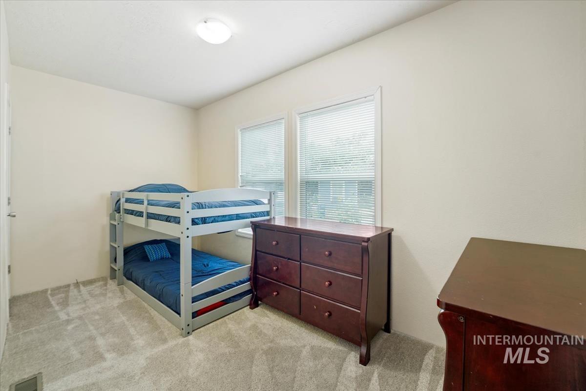 Bedroom featuring light carpet