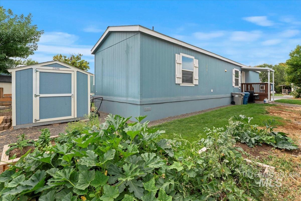 View of property exterior featuring a storage shed, crawl space, and a lawn