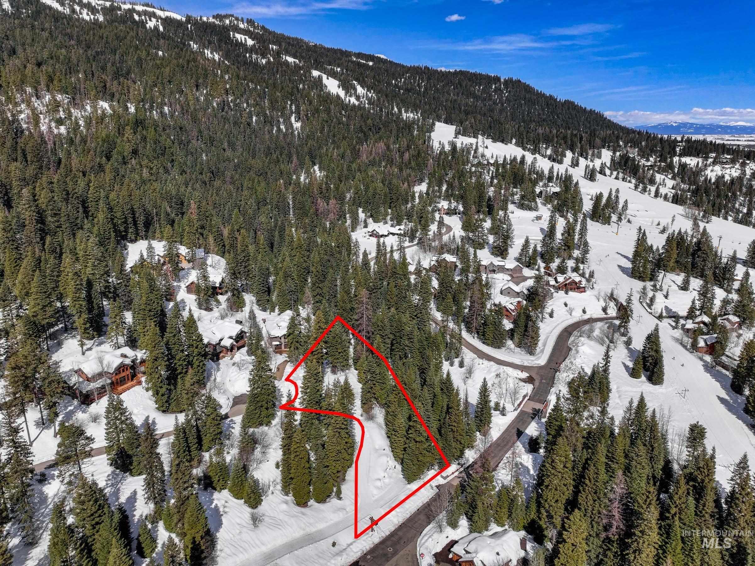 Aerial overview of property's location featuring property boundaries highlighted and a mountainous background