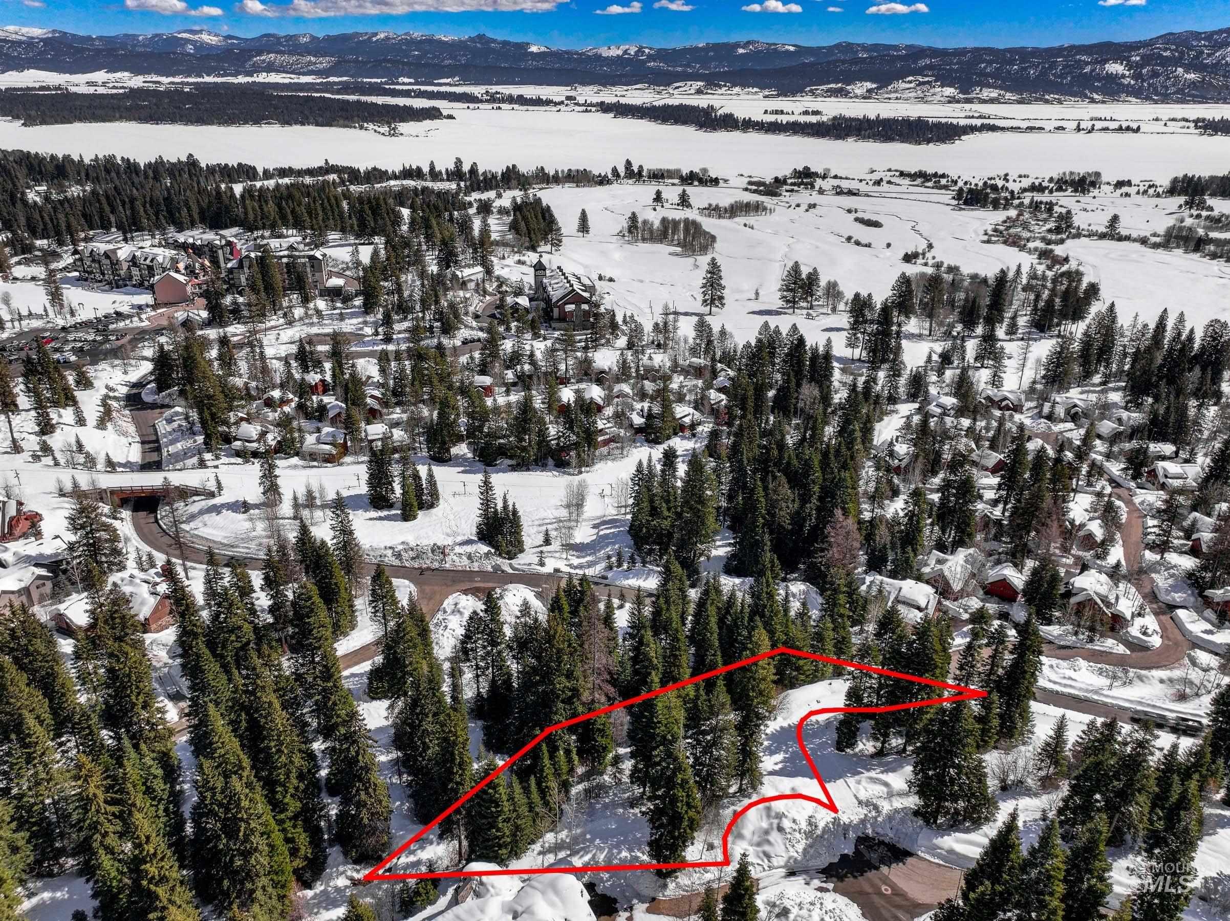 Snowy aerial view featuring a mountain view and property parcel outlined