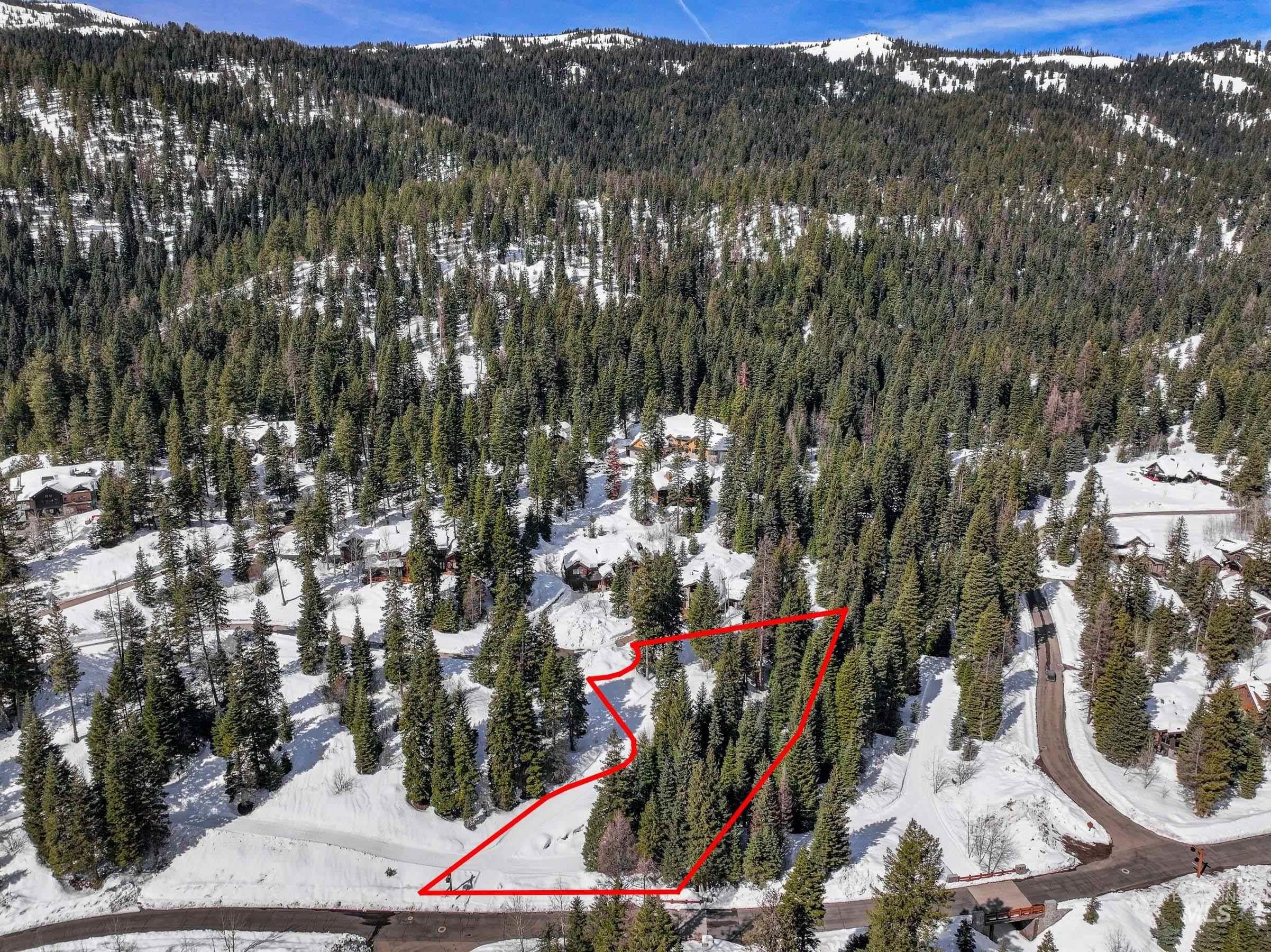 Aerial overview of property's location with property parcel outlined and a mountain backdrop
