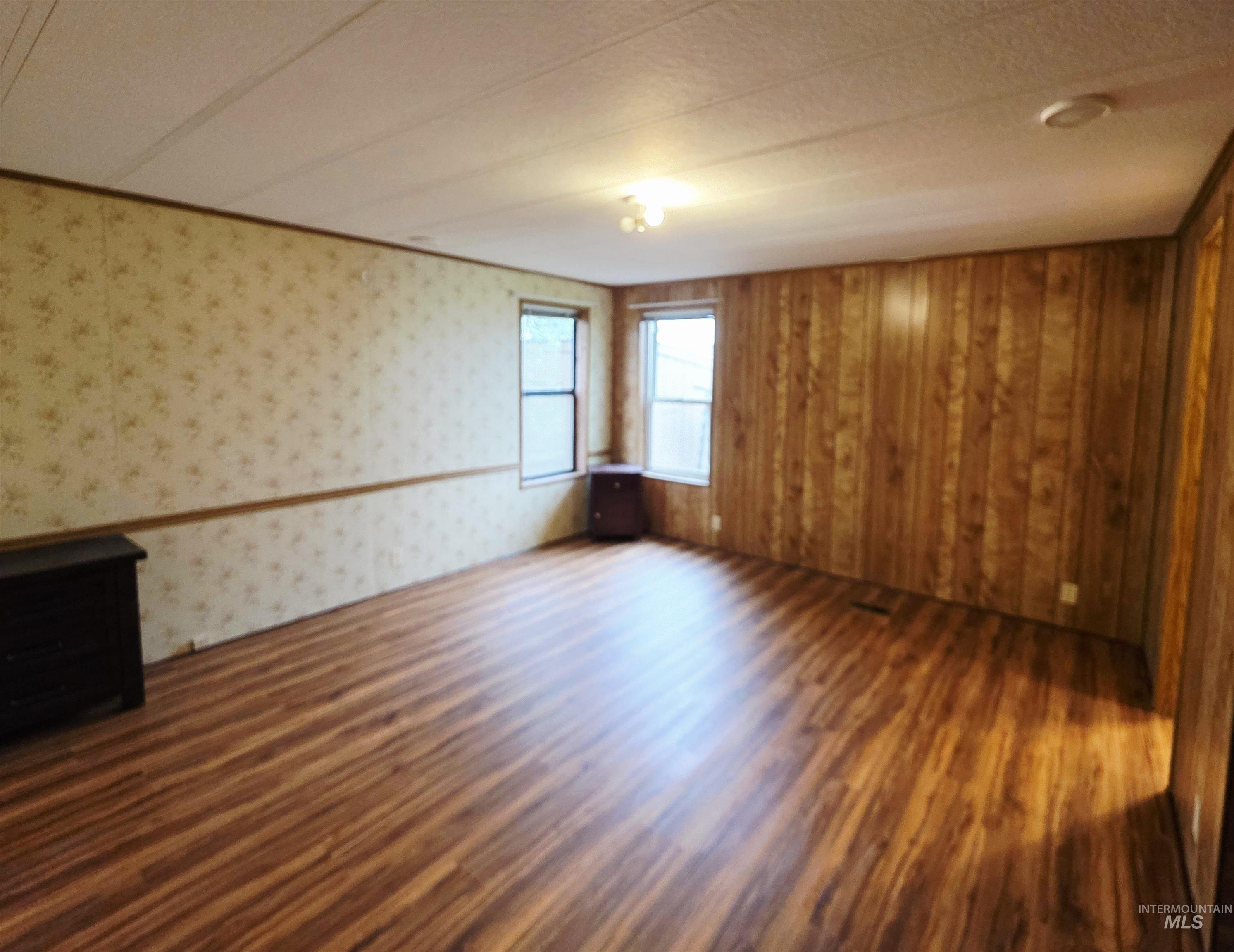 Spare room with dark wood-style flooring