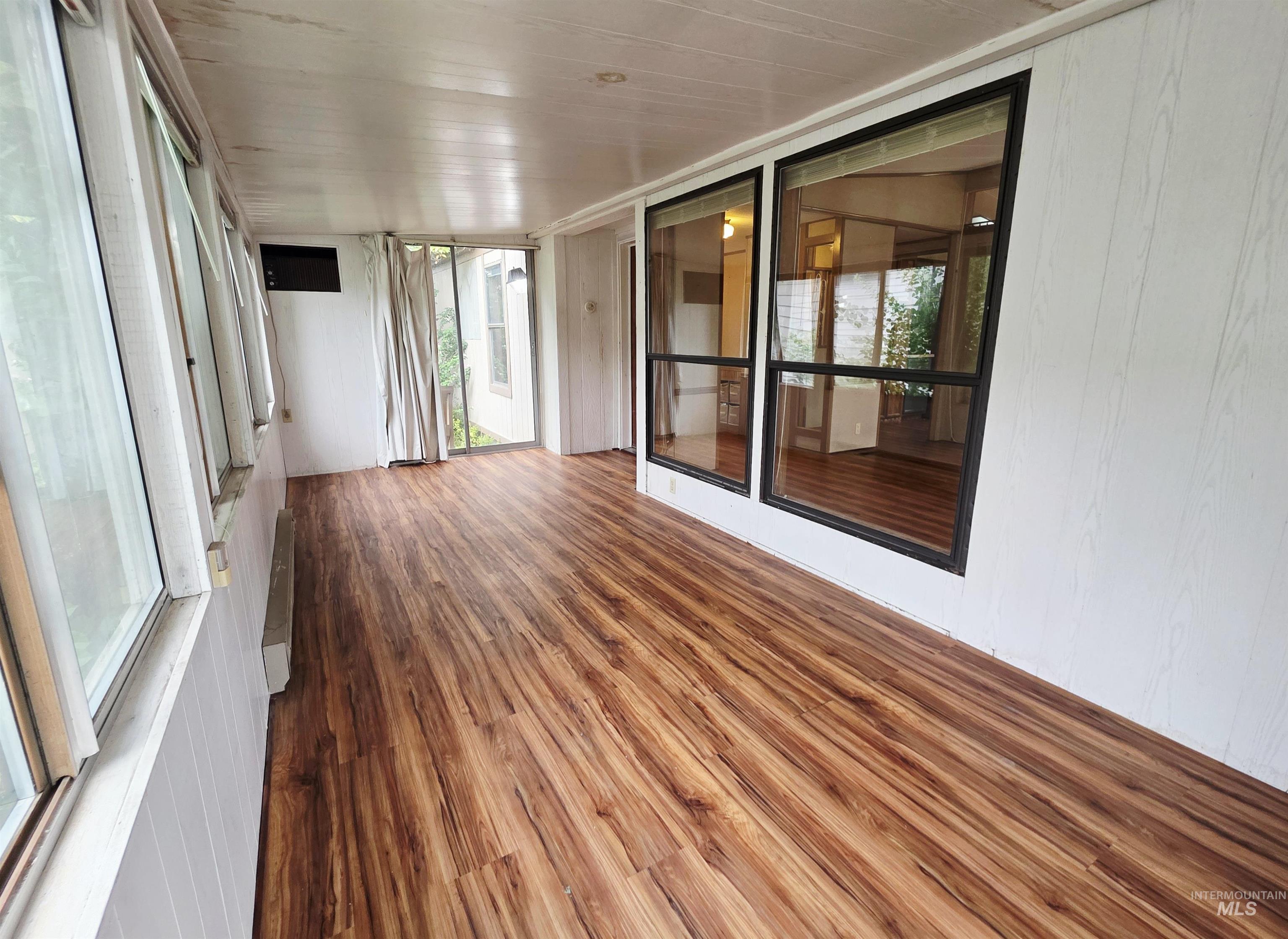 Unfurnished sunroom featuring wood finished floors