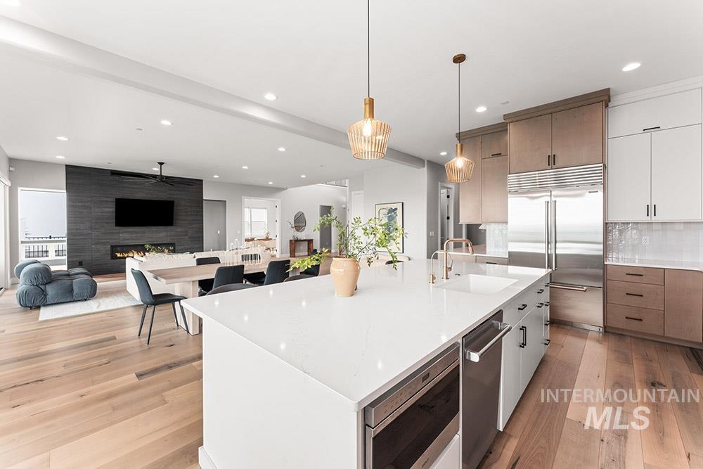 Kitchen with white cabinets, modern cabinets, open floor plan, a large island with sink, and recessed lighting