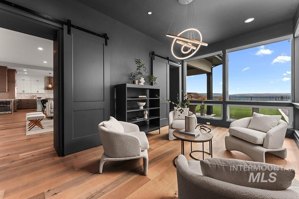 Living area with a barn door, recessed lighting, and wood finished floors