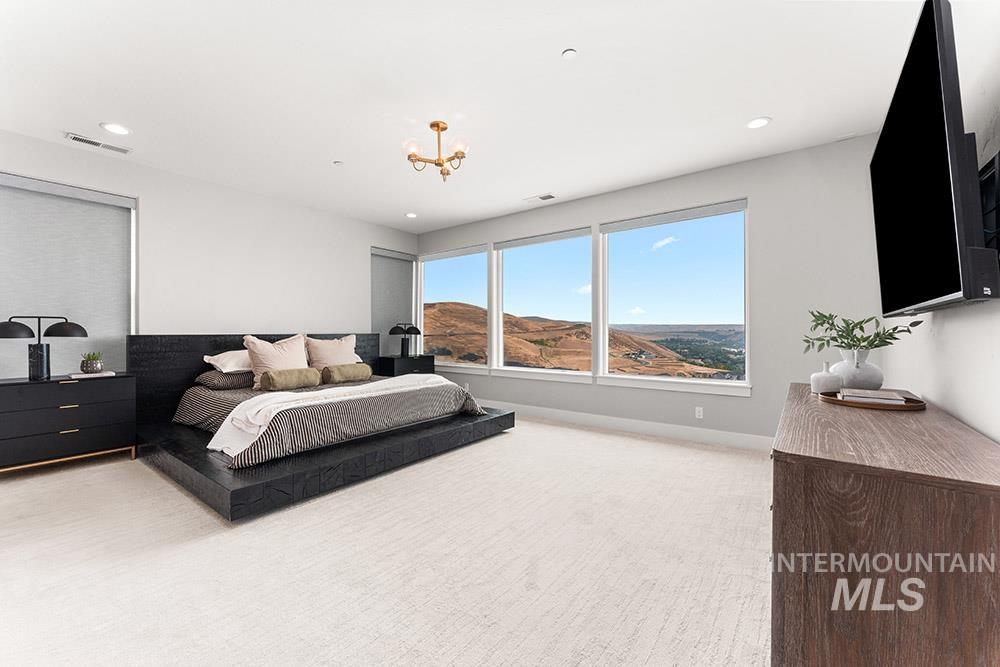 Bedroom with light colored carpet, recessed lighting, and a chandelier