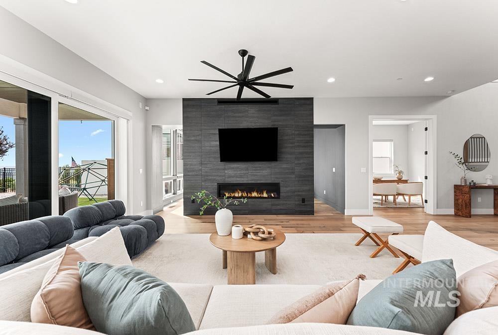 Living room featuring healthy amount of natural light, a tile fireplace, recessed lighting, wood finished floors, and a ceiling fan