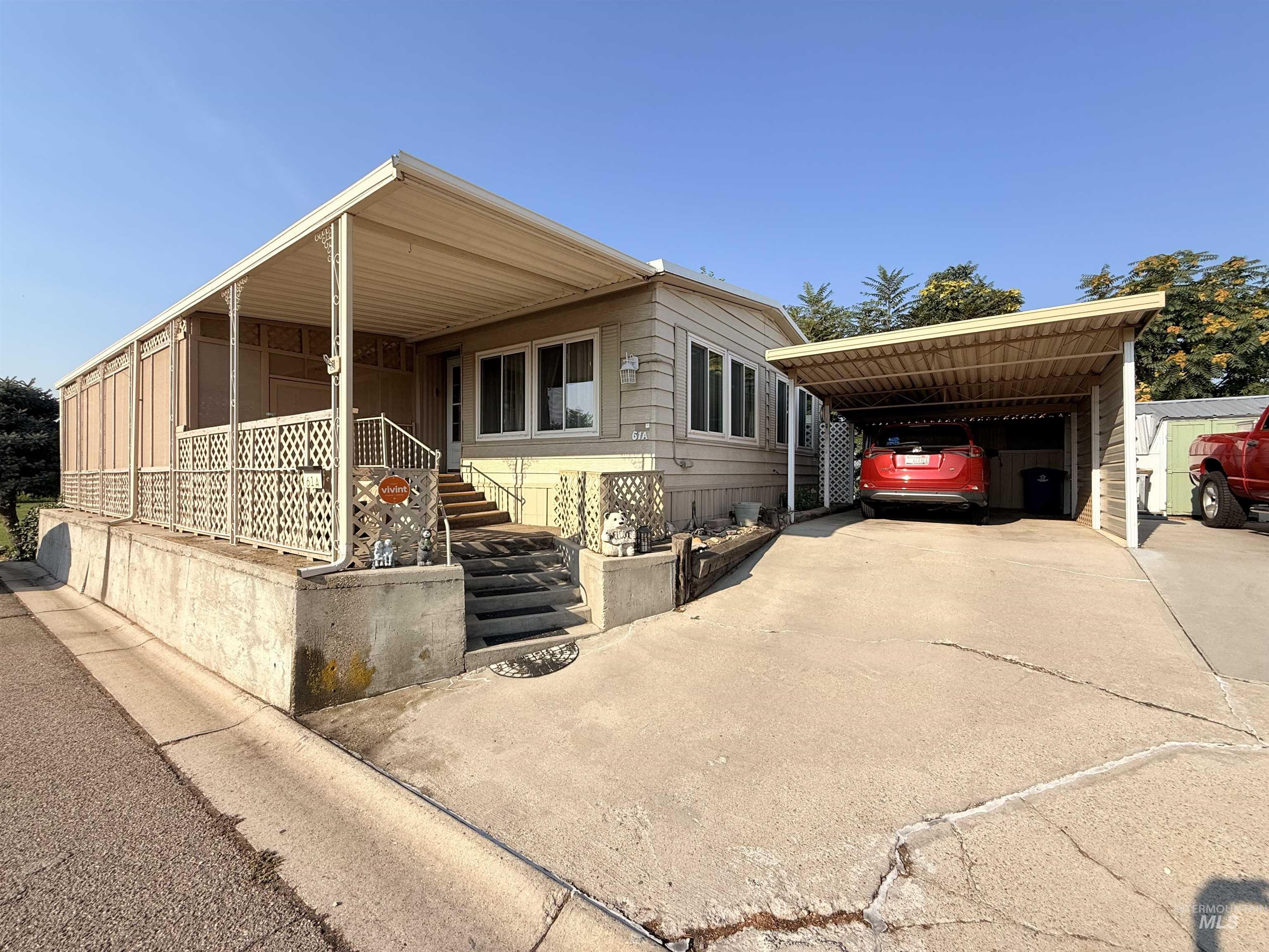 View of front facade featuring a carport, concrete driveway, and covered porch