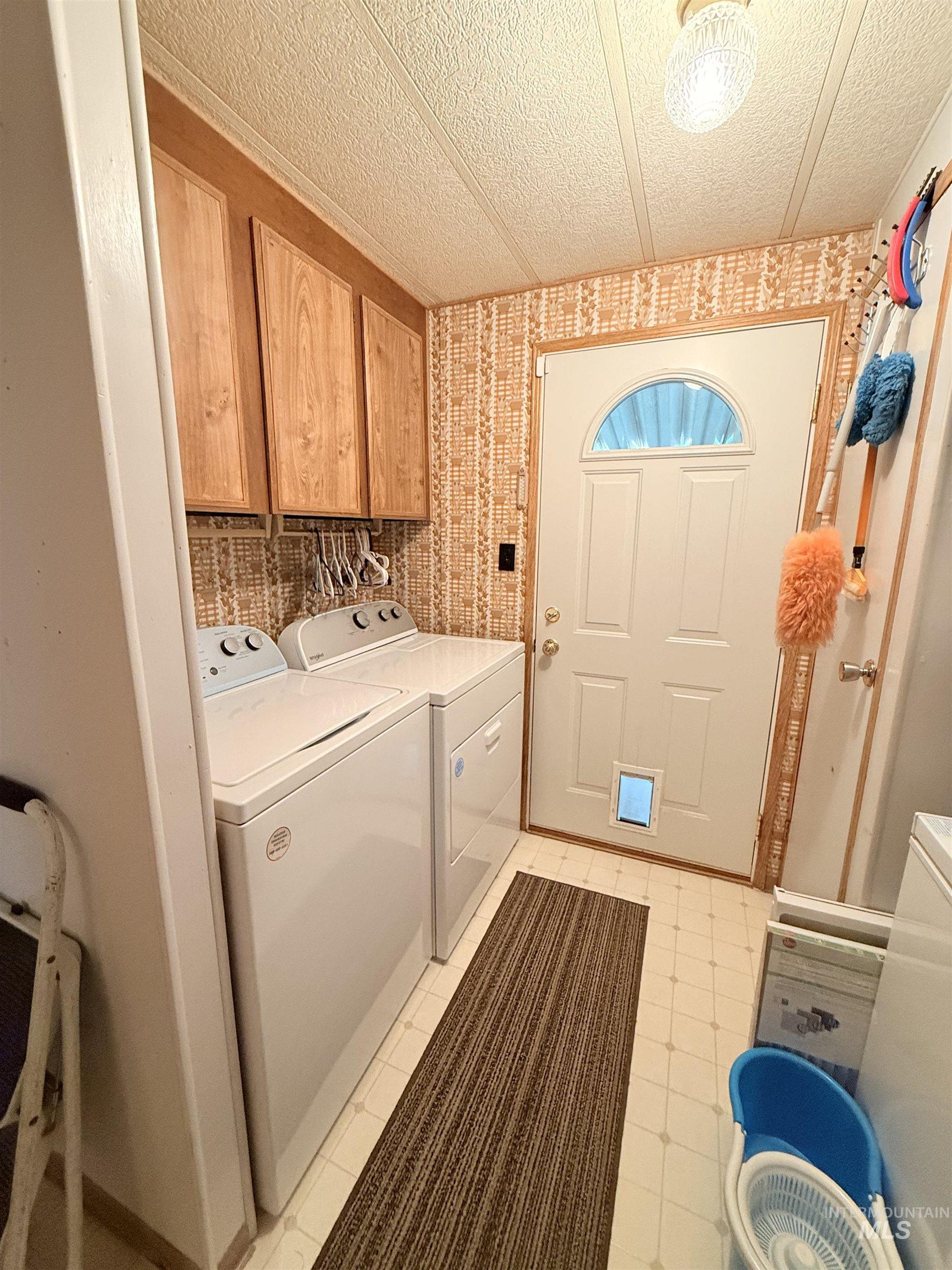 Laundry room with washer and dryer and a textured ceiling