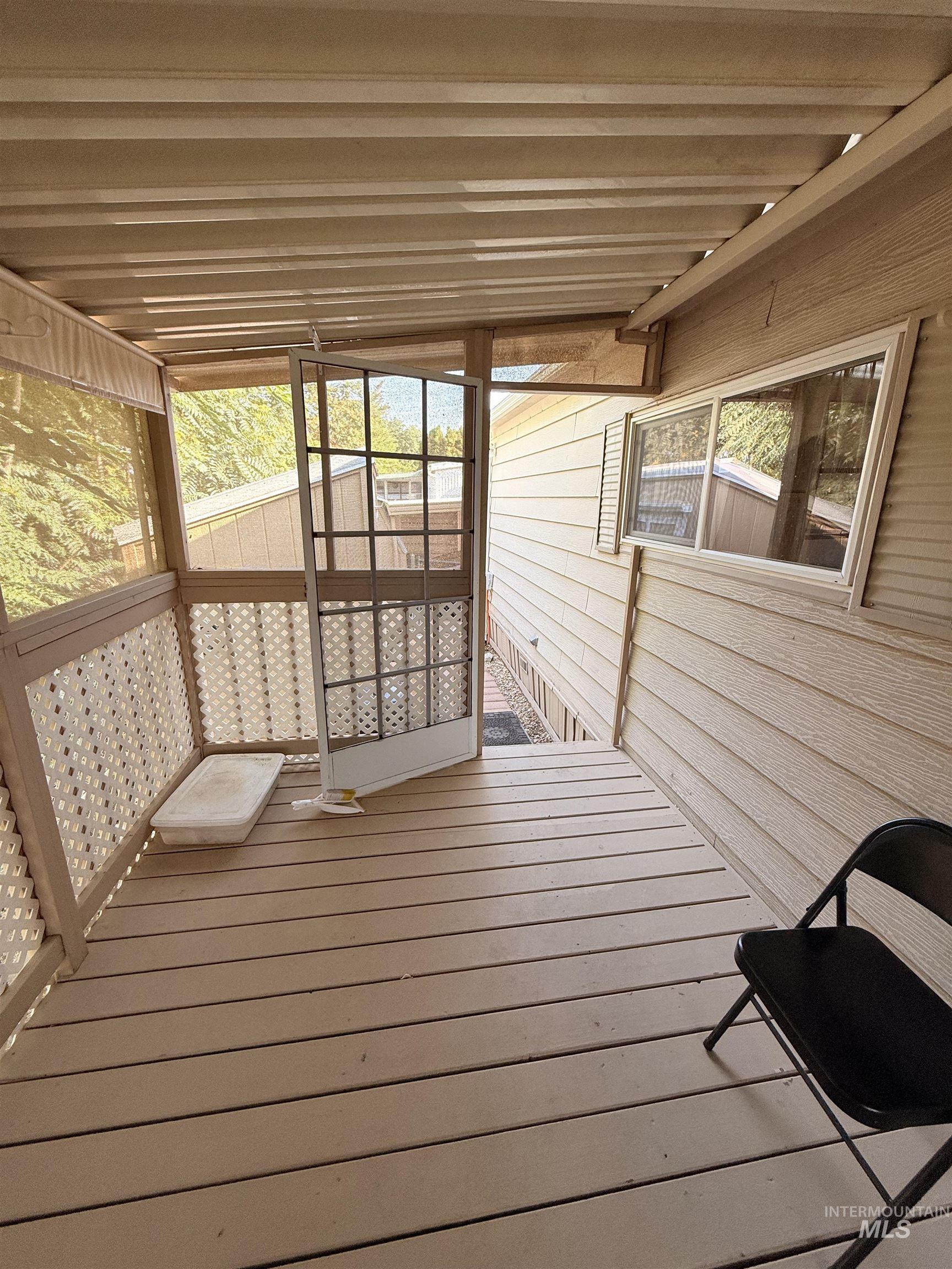 Wooden terrace featuring a sunroom