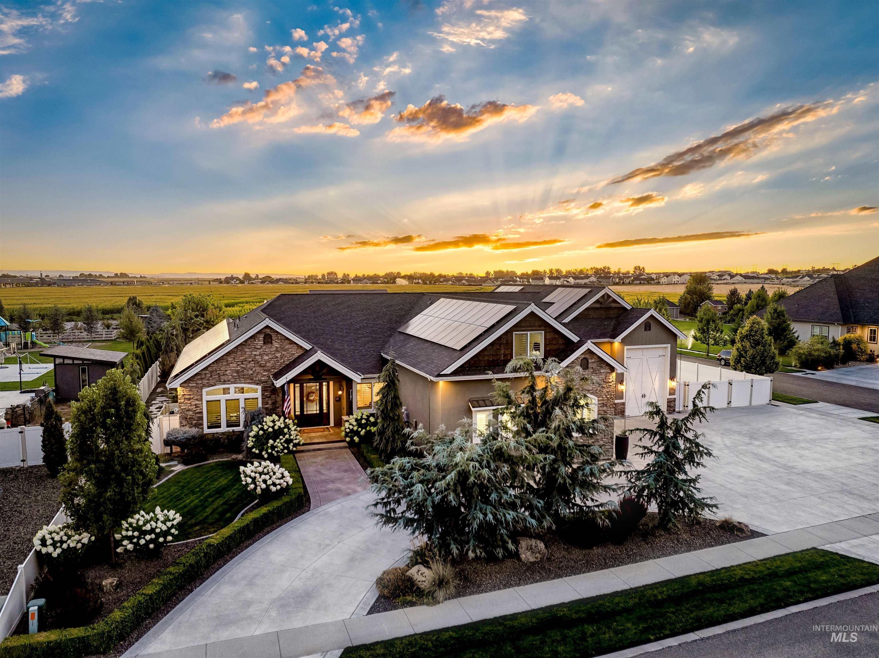 Craftsman inspired home featuring stone siding, driveway, and solar panels