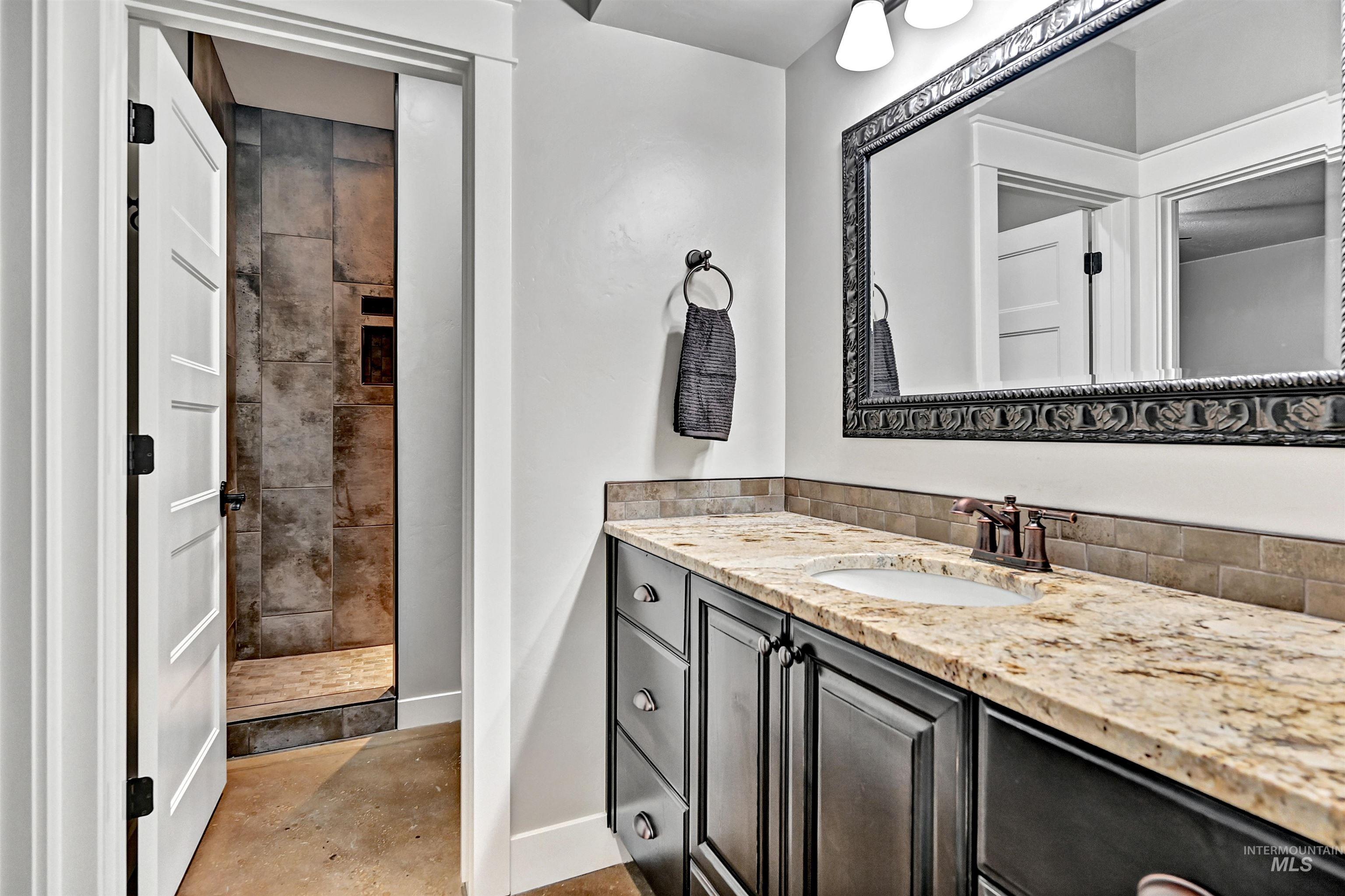 Bathroom with vanity, a stall shower, and concrete flooring