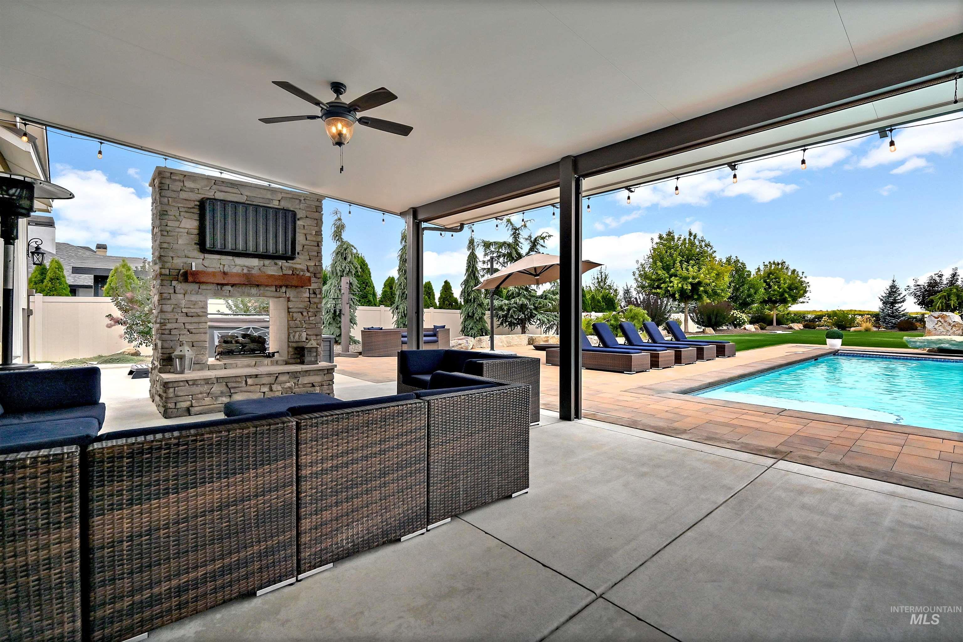 View of patio / terrace featuring an outdoor pool, ceiling fan, and an outdoor living space with a fireplace