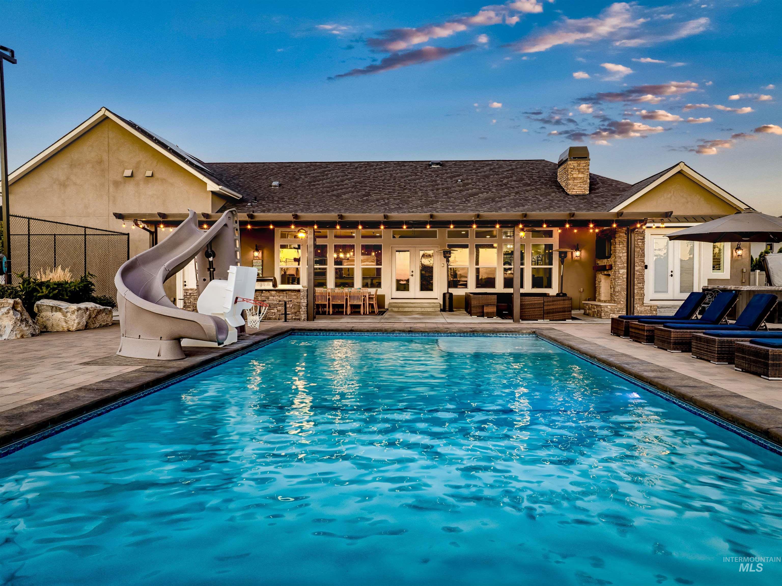 Swimming pool featuring a water slide, a patio, and french doors