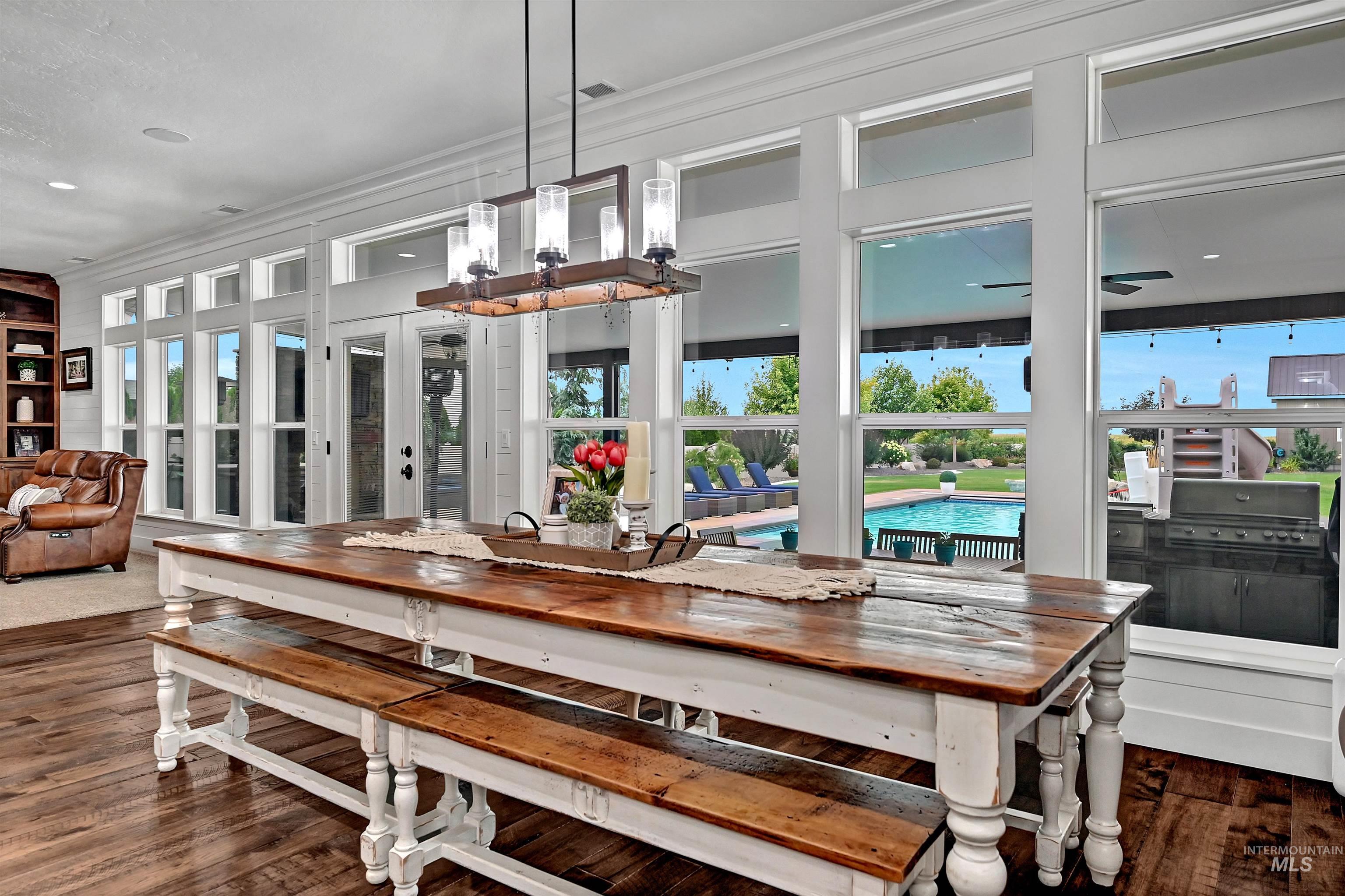 Dining space with dark wood-style floors, healthy amount of natural light, french doors, and crown molding