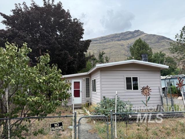 View of front of house featuring a mountain view, a fenced front yard, and a gate