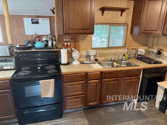 Kitchen featuring black appliances, light countertops, and dark wood-style flooring