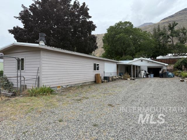 Back of property featuring a mountain view and a chimney