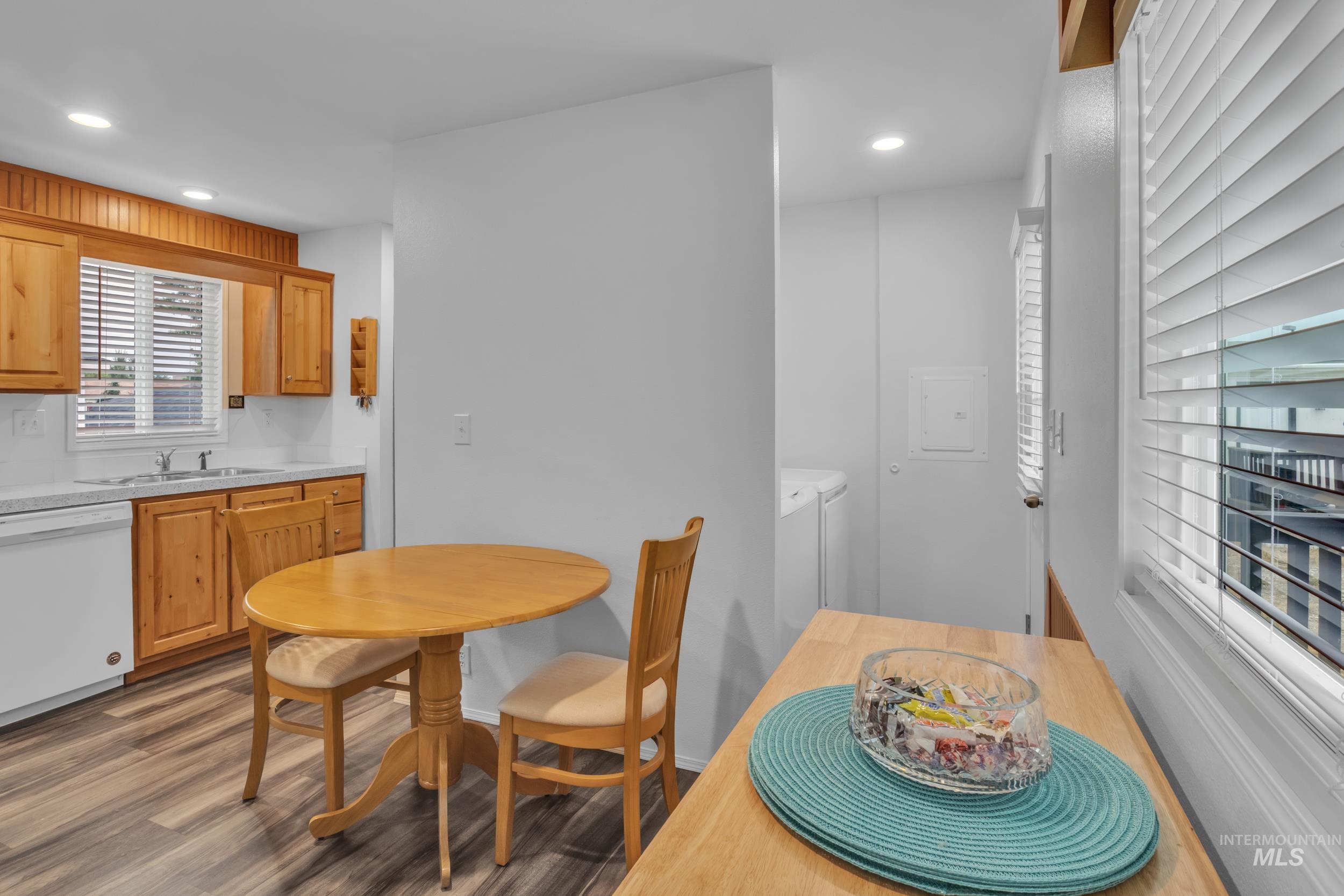 Dining area featuring dark wood-style flooring, washing machine and clothes dryer, and recessed lighting