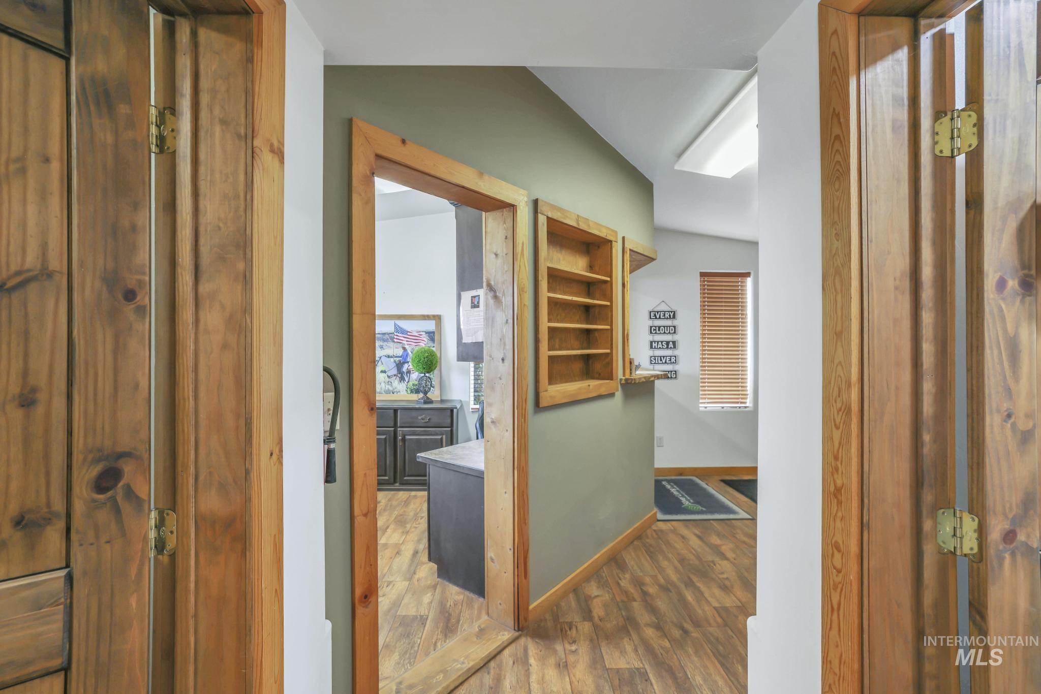 Corridor with dark wood-style flooring and baseboards