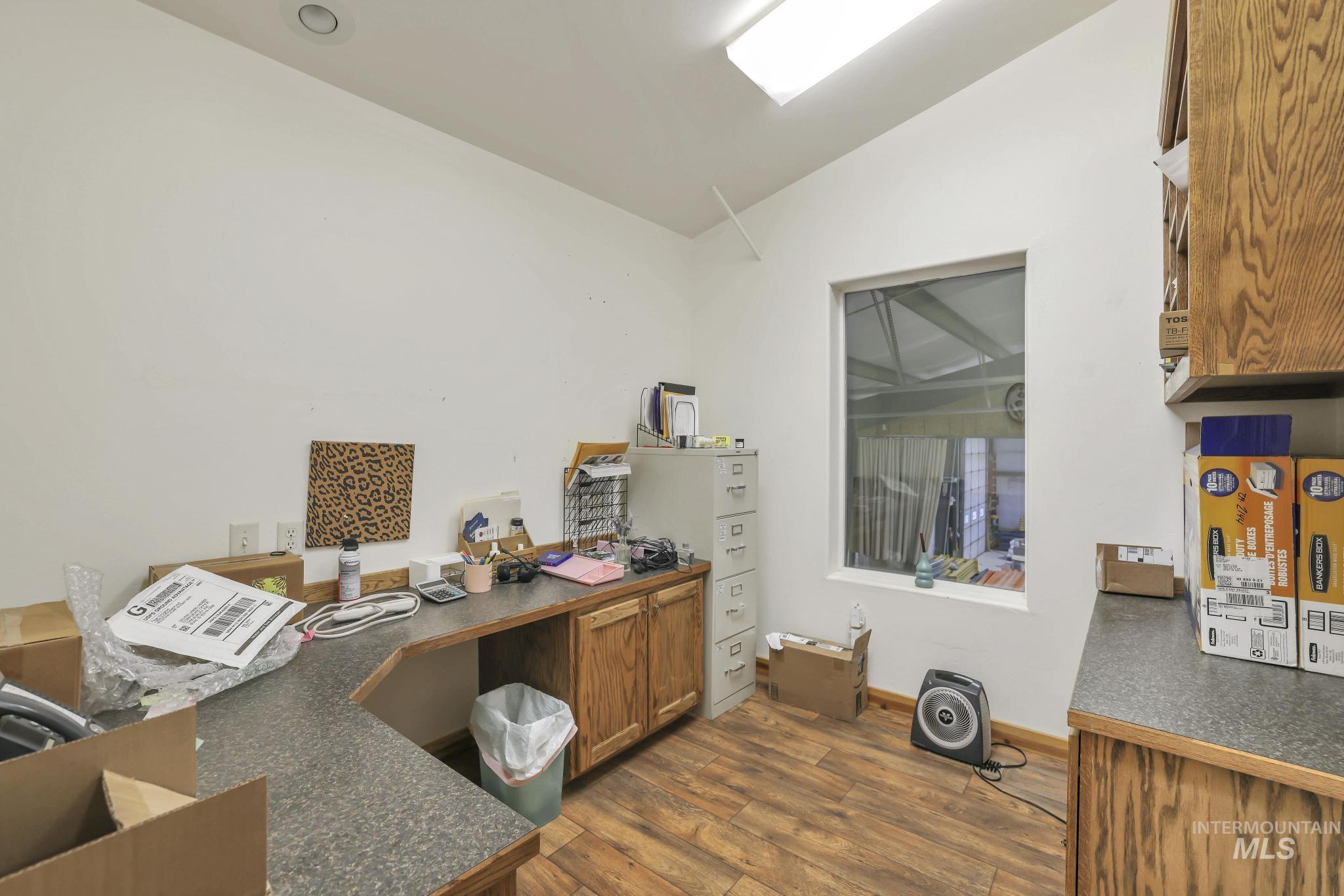 Office area featuring dark wood-style flooring and lofted ceiling