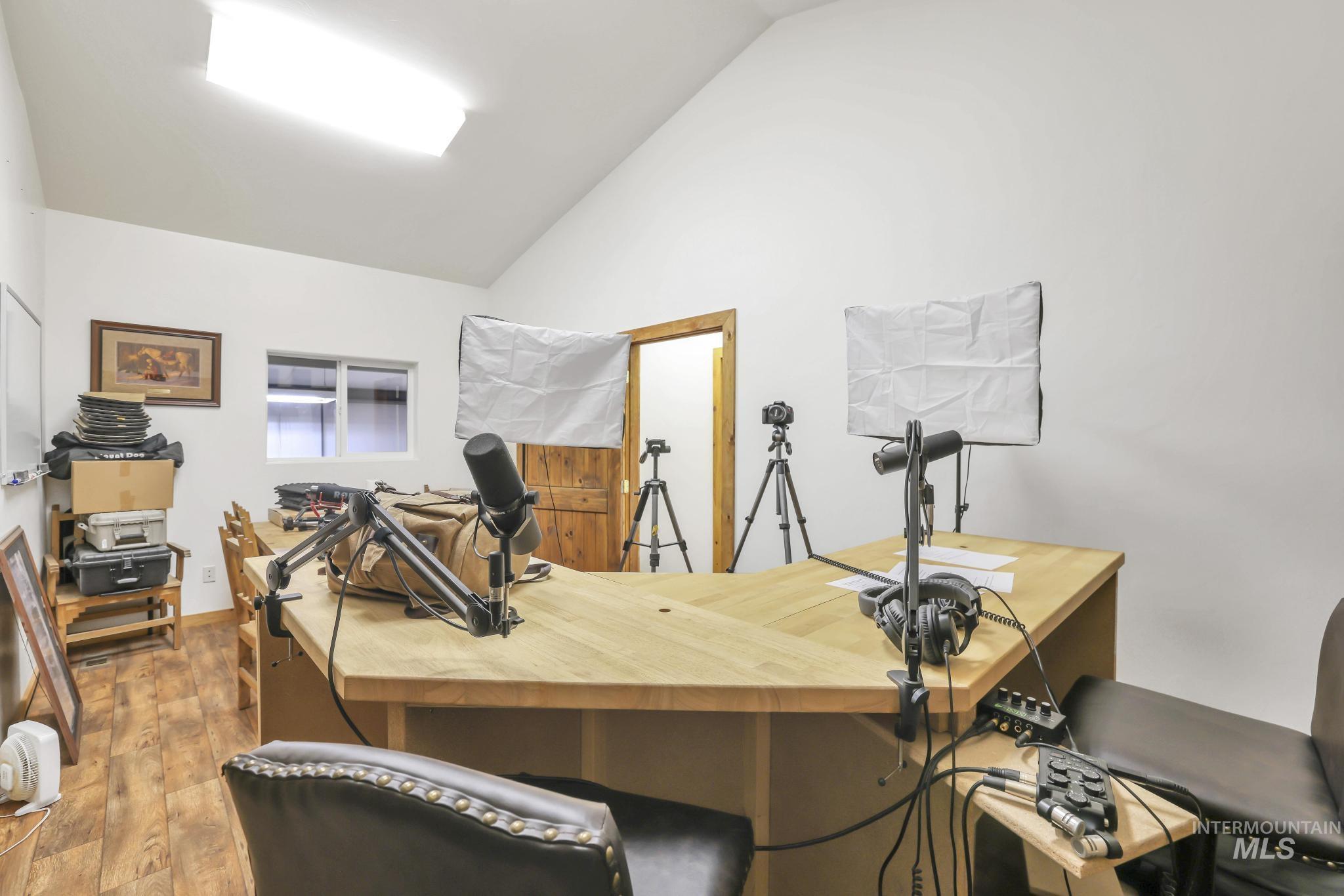 Office area with vaulted ceiling and wood finished floors