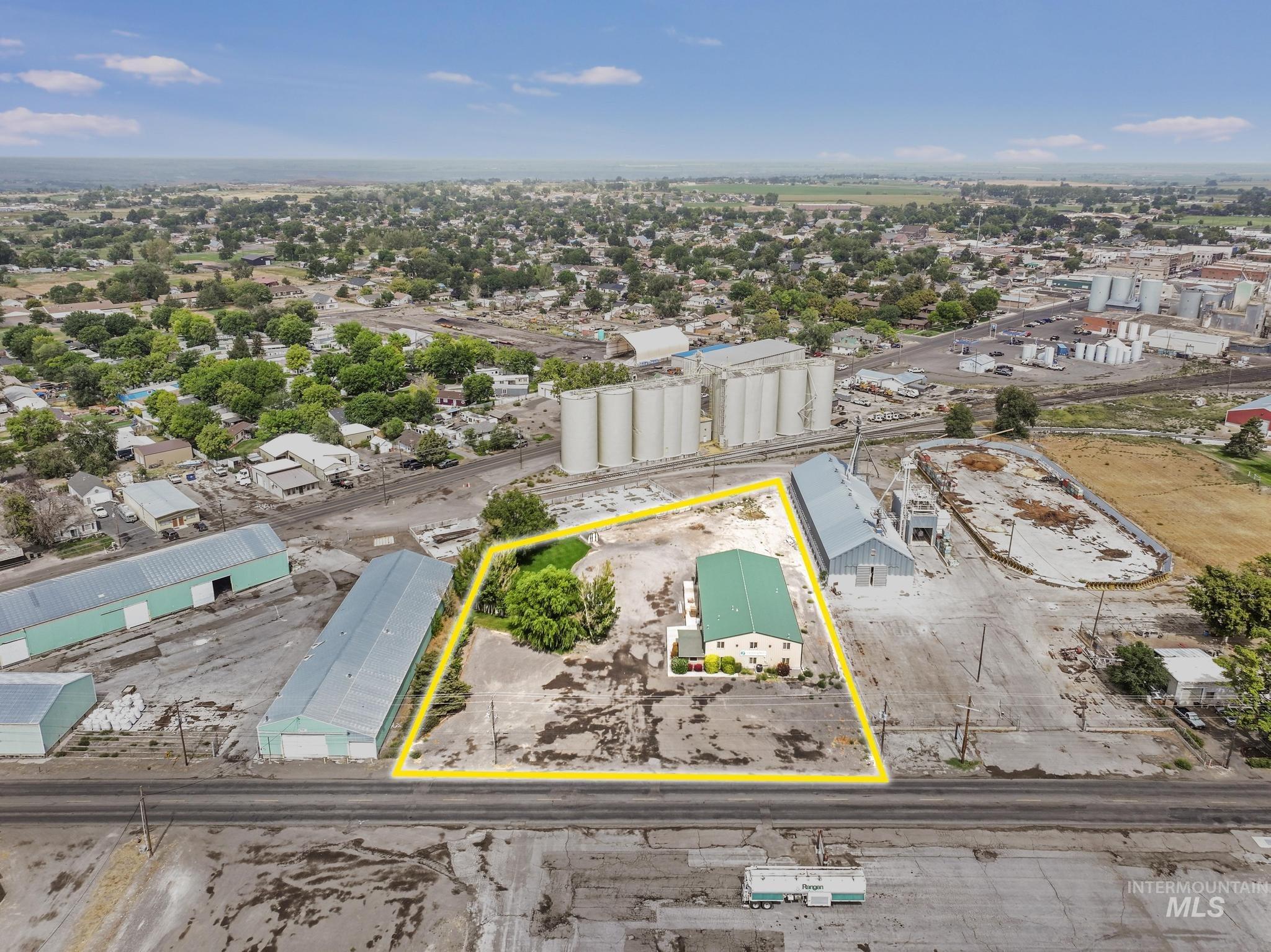 Aerial view of property and surrounding area featuring an industrial area and property parcel outlined