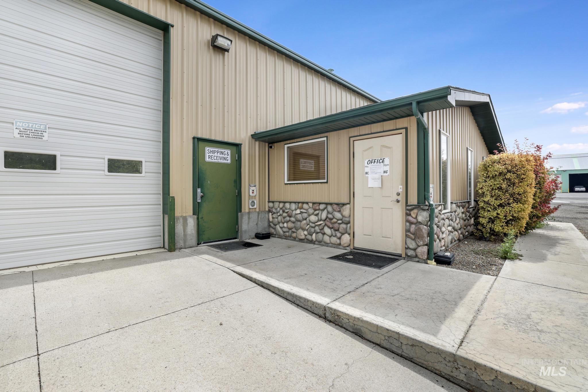 Doorway to property with stone siding and board and batten siding