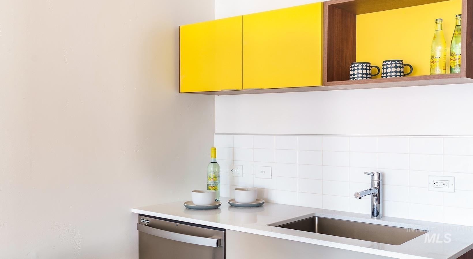 Kitchen featuring dishwasher, tasteful backsplash, light stone counters, and open shelves