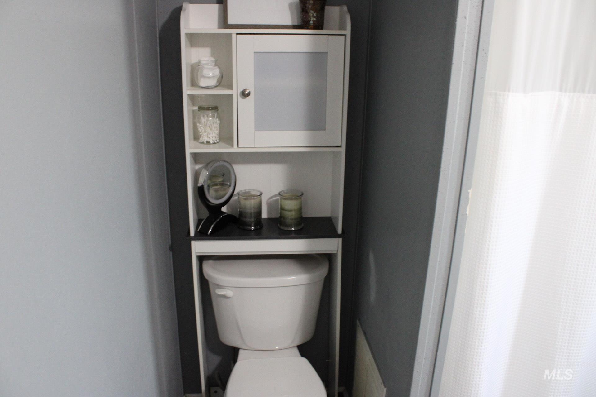 Bathroom featuring toilet and a shower with curtain