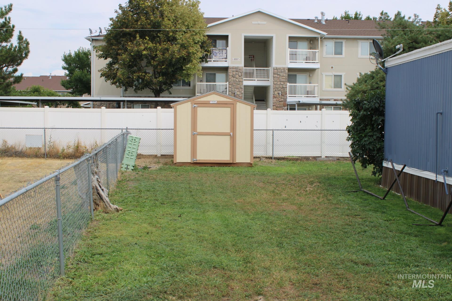 Fenced backyard featuring a shed