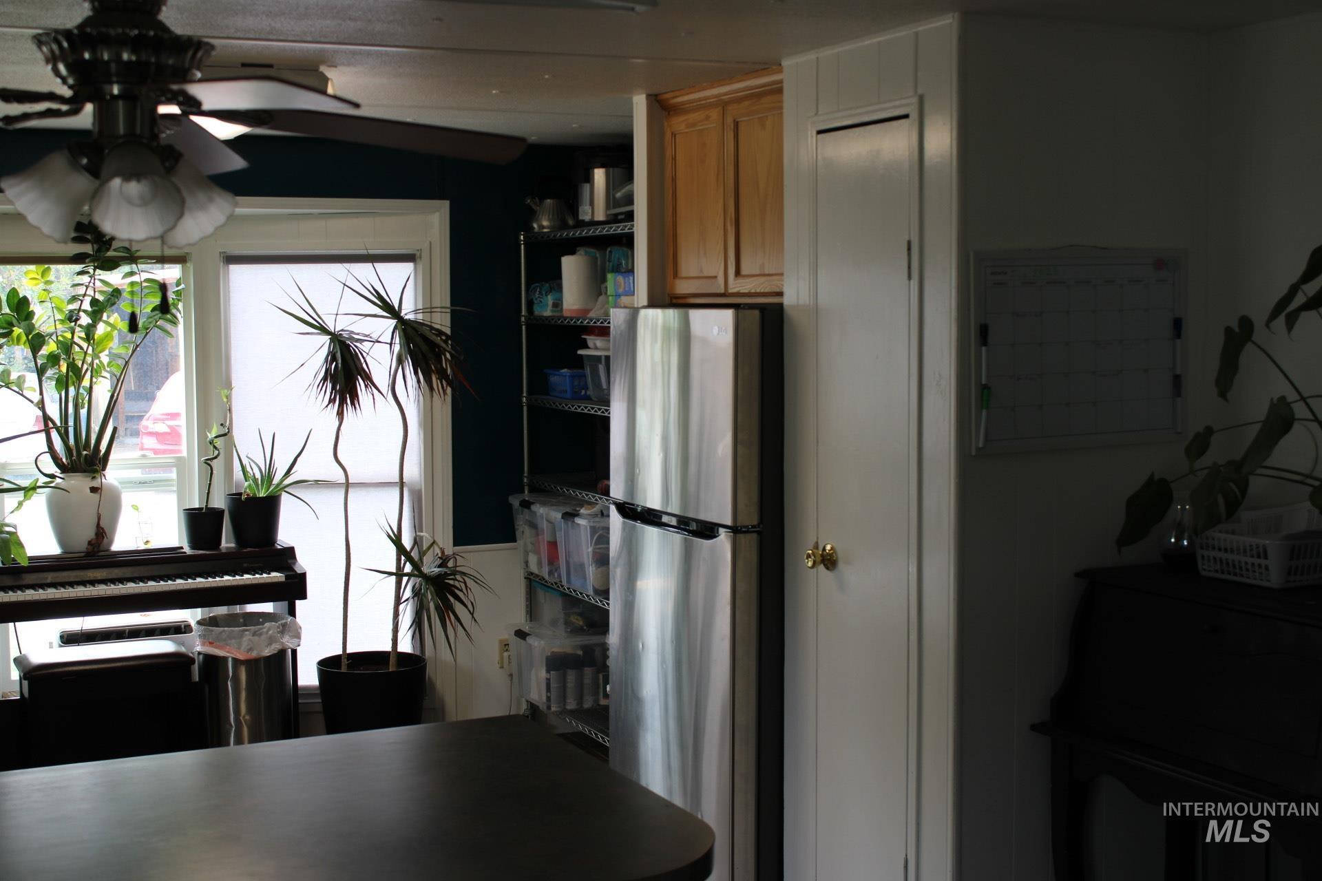 Kitchen featuring freestanding refrigerator, ceiling fan, brown cabinets, and open shelves