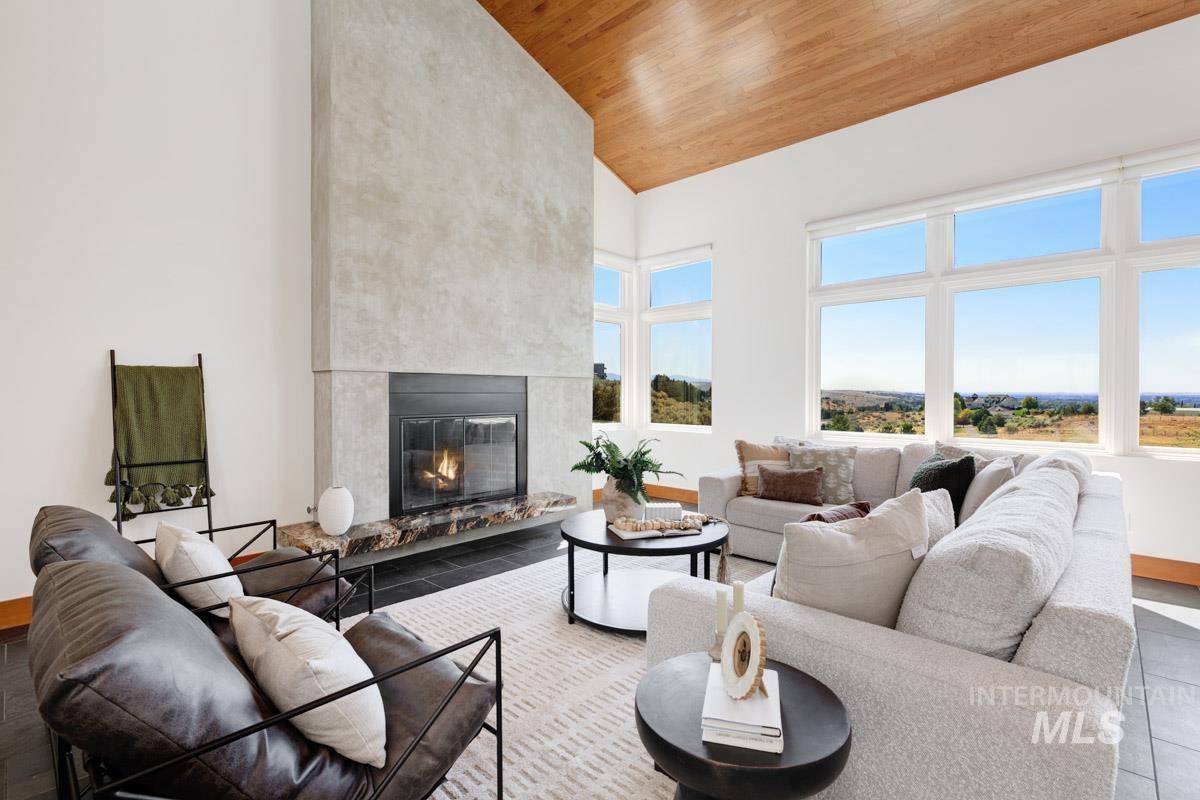 Living room with high vaulted ceiling, a fireplace, and wooden ceiling