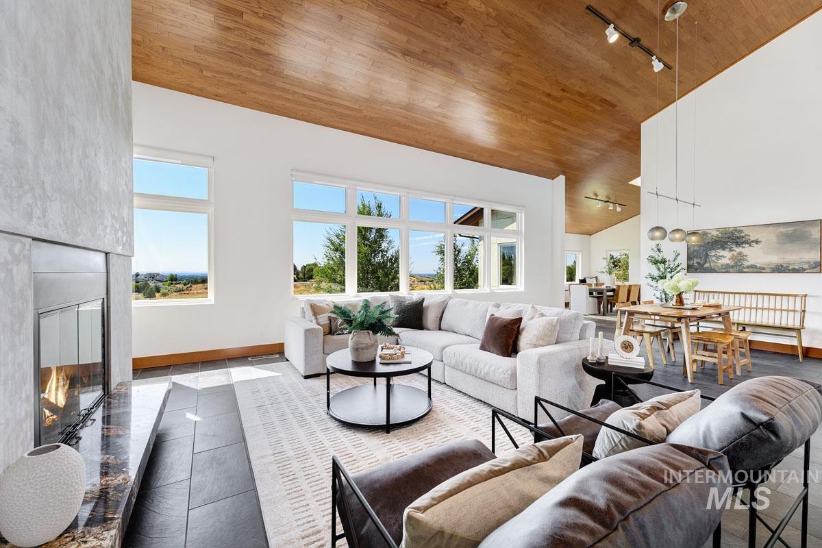 Tiled living room with a premium fireplace, high vaulted ceiling, plenty of natural light, and wooden ceiling