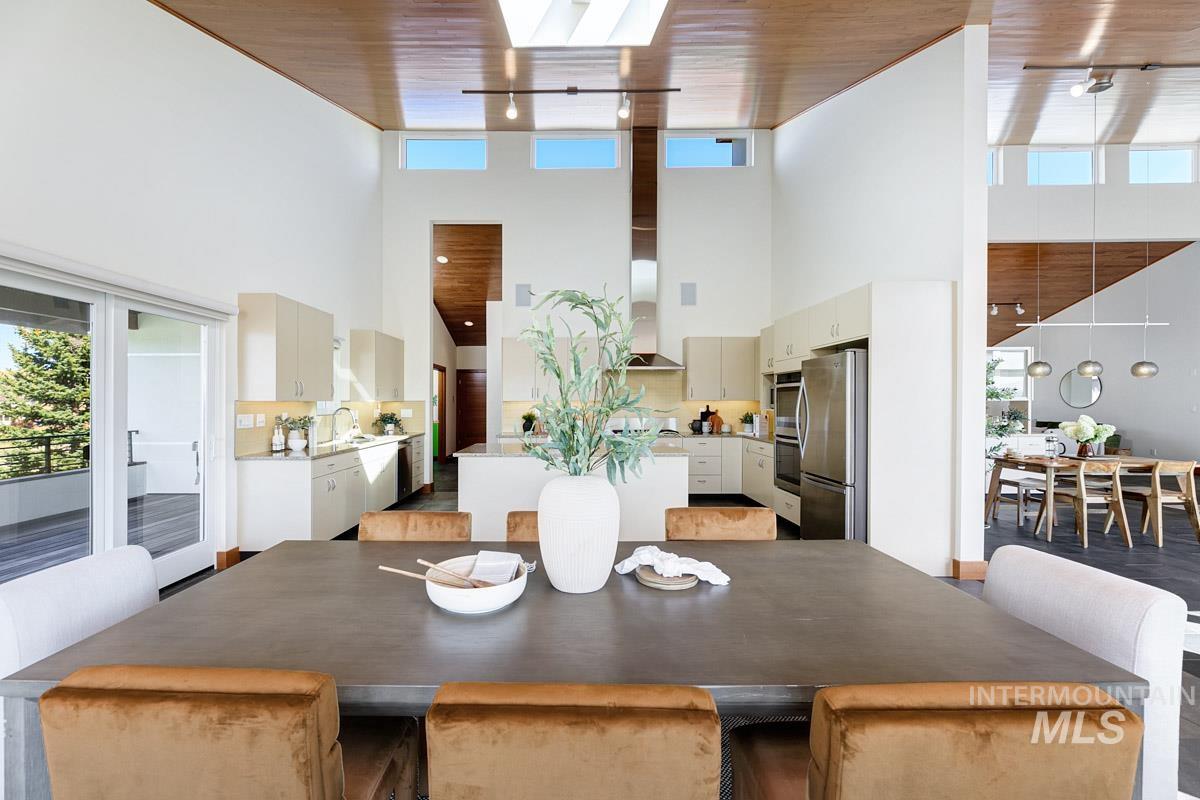 Dining area with track lighting, a high ceiling, and wooden ceiling