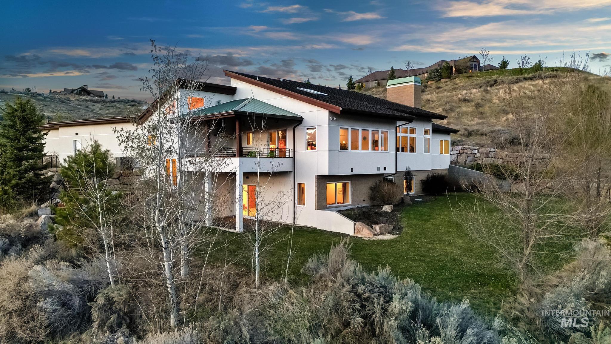 Rear view of property featuring a balcony, a chimney, and stucco siding