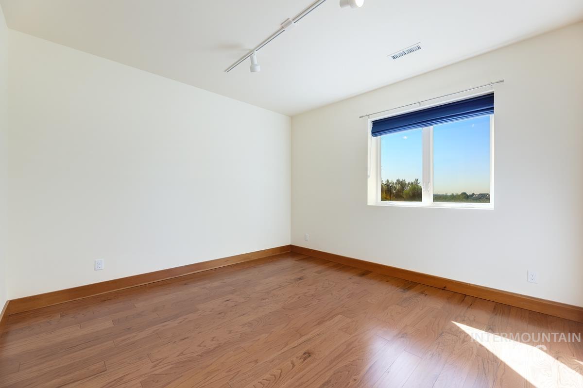 Unfurnished room featuring rail lighting and light wood finished floors