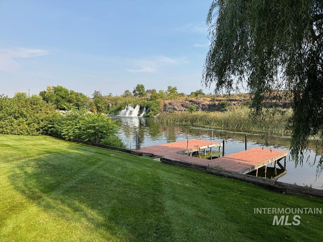 Dock area with a water view and a yard